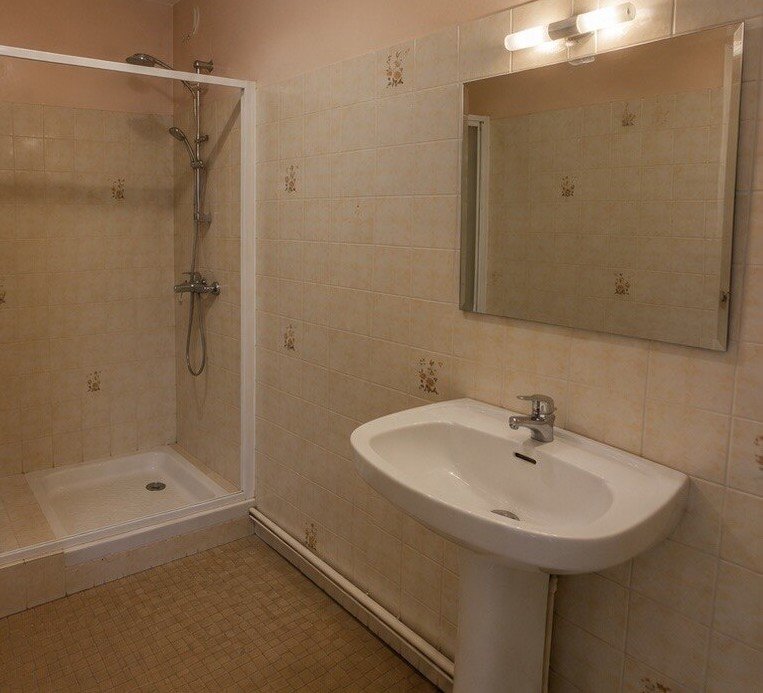 Salle de bain avant rénovation : douche vétuste, faïence datée, vasque sur pied