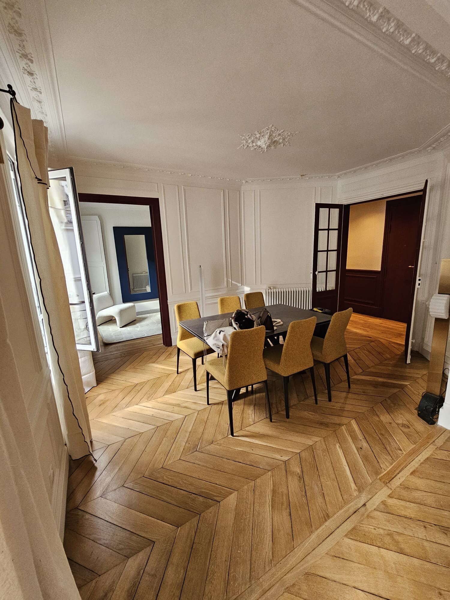 Salle à manger avec chaises jaune moutarde et parquet point de Hongrie