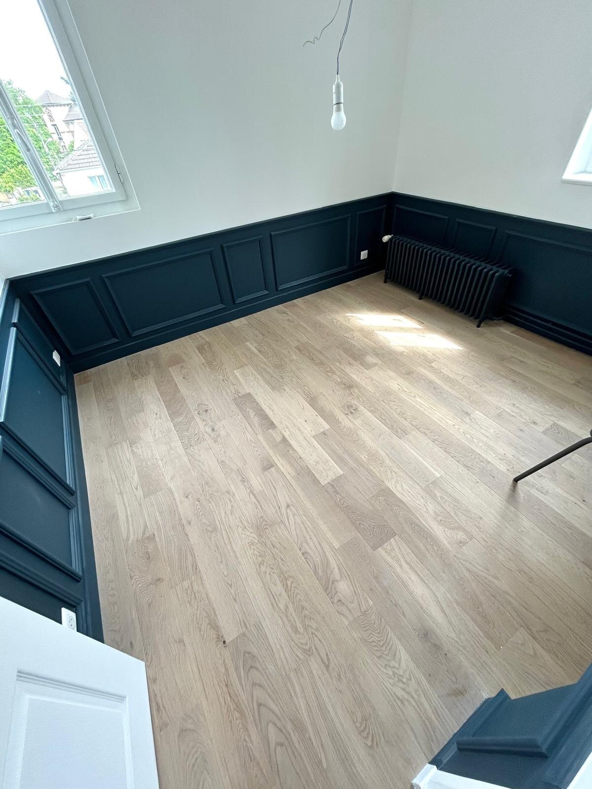 Séjour avec cimaises bleu canard et parquet massif
